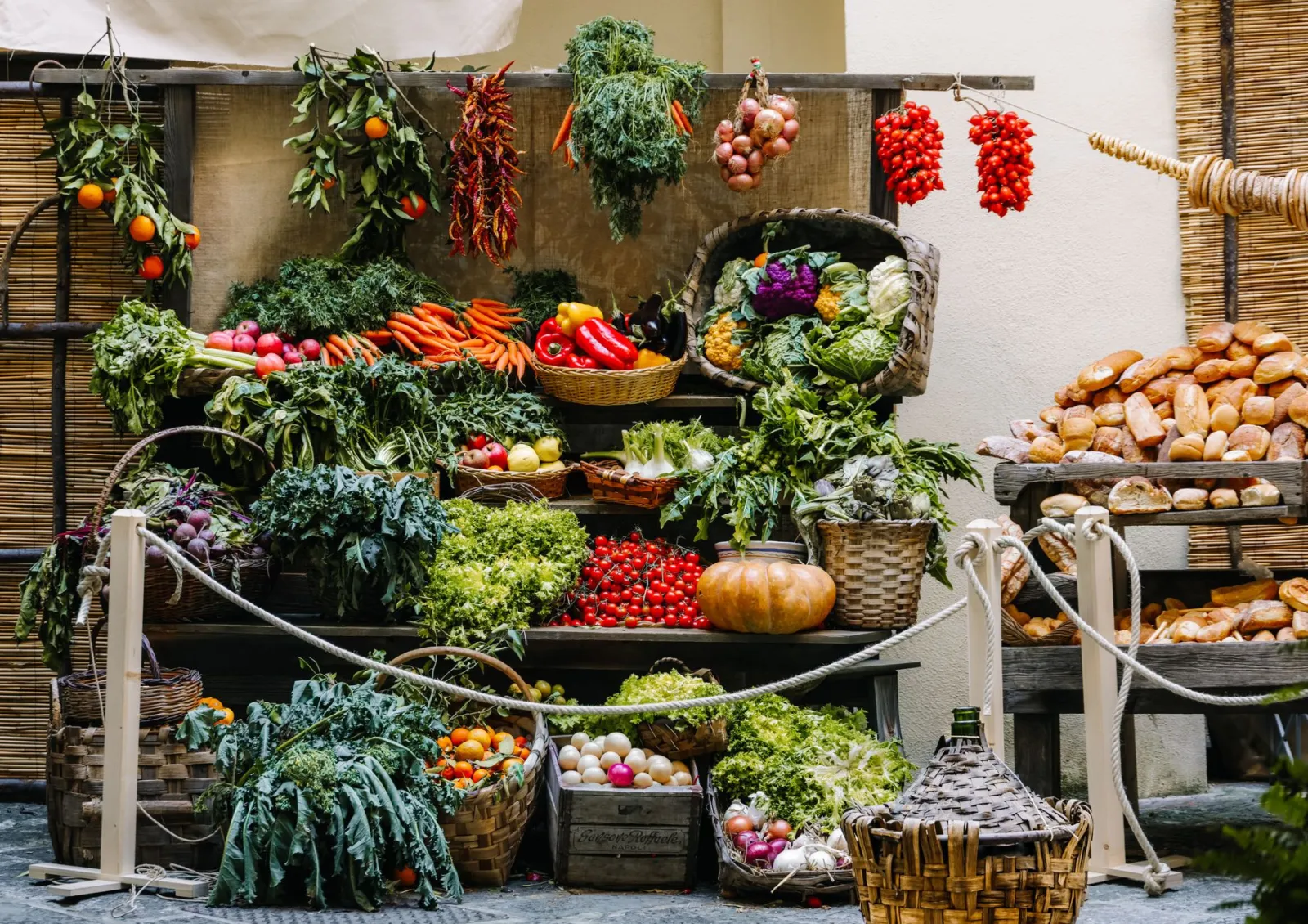 Vibrant array of fresh produce and bread at a farmer's market stand, showcasing seasonal vegetables and baked goods.